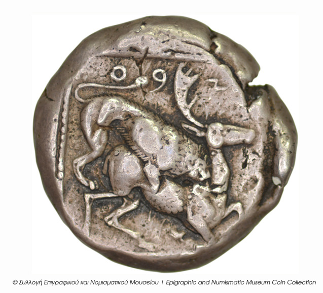 Οπισθότυπος 'SilCoinCy B5, Kyrou Collection, acc.no.: ΒΠ 1989 - 5. Silver coin of king Ozibaal of Kition 450 - 425 BC. Weight: 10.76g, Axis: 7h, Diameter: 22mm. Obverse type: Herakles walking r.. Obverse symbol: -. Obverse legend: - in -. Reverse type: Lion devouring stag r.. Reverse symbol: -. Reverse legend: zb' in Phoenician. 'Les monnaies chypriotes dans la collection d'Adonis Kyrou'.